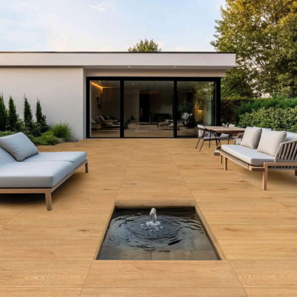 Example Furnishing Of A Terrace With OAK Classic Parquet, Two Sofas With Beige Upholstery Covers On The Left And Right, In The Foreground A Rectangular Fountain In A Recess In The Parquet, In The Background A Residential Bungalow And On The Right A Deciduous Tree